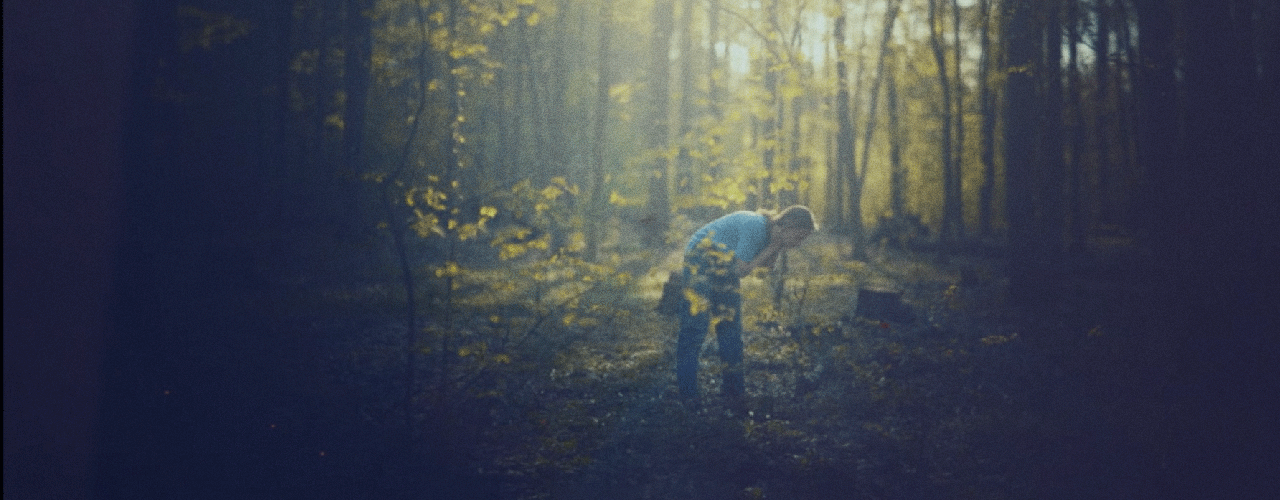 Une personne cherche quelque chose par terre dans la forêt